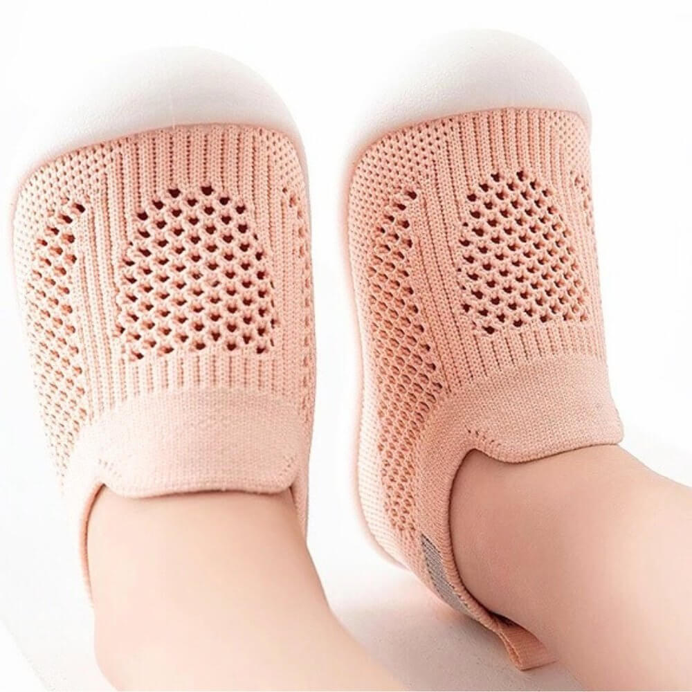 Developmental shoe collection featuring soft-bottom slippers for newborns through hard-bottom walking shoes for 12-month-olds.